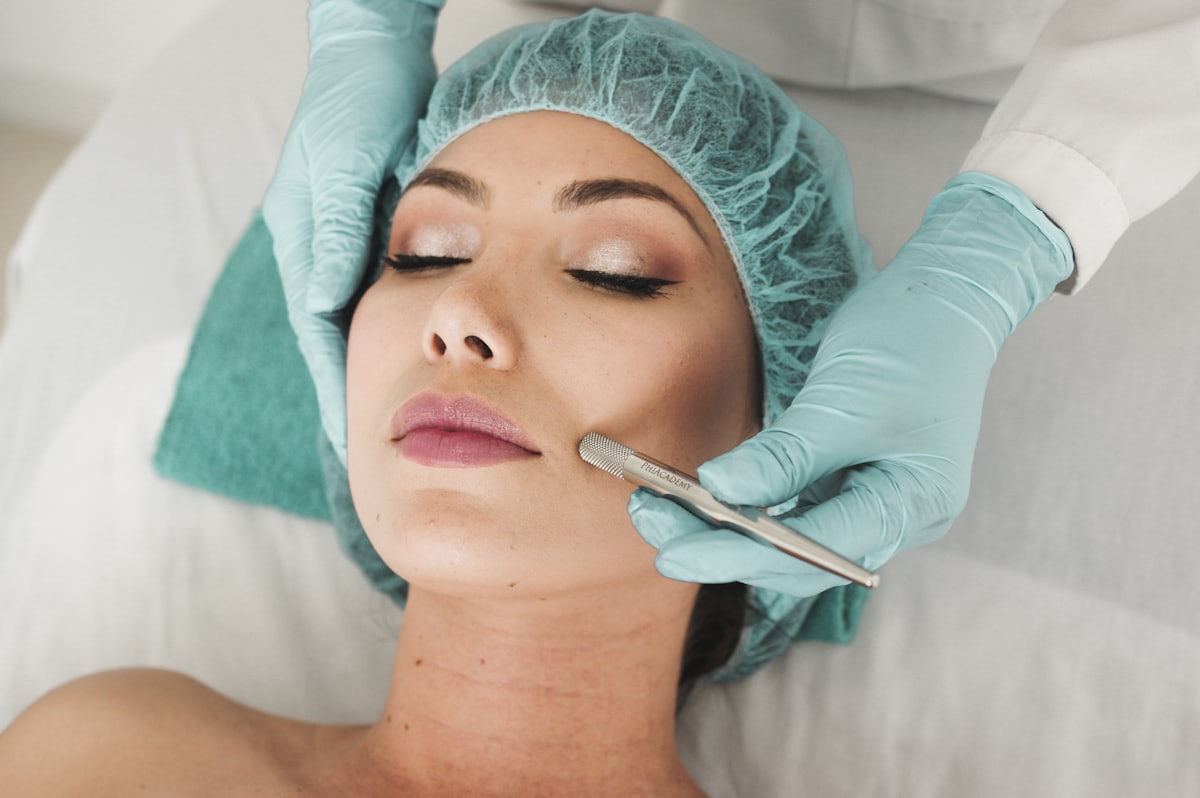 A gloved practitioner using a device during a treatment